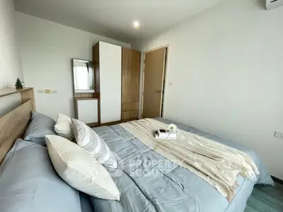 Cozy bedroom with modern decor and ample natural light, featuring a comfortable bed and stylish wardrobe.