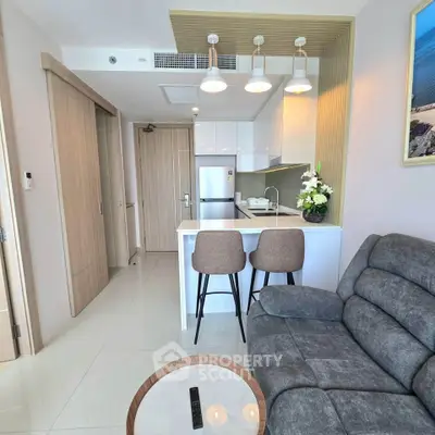 Modern open-layout kitchen and living room with sleek design and cozy seating area.