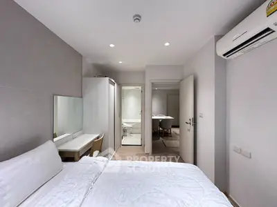 Modern bedroom with ensuite bathroom and air conditioning in a stylish apartment.