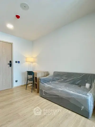 Modern minimalist living room with sofa and wooden flooring, perfect for cozy urban living.