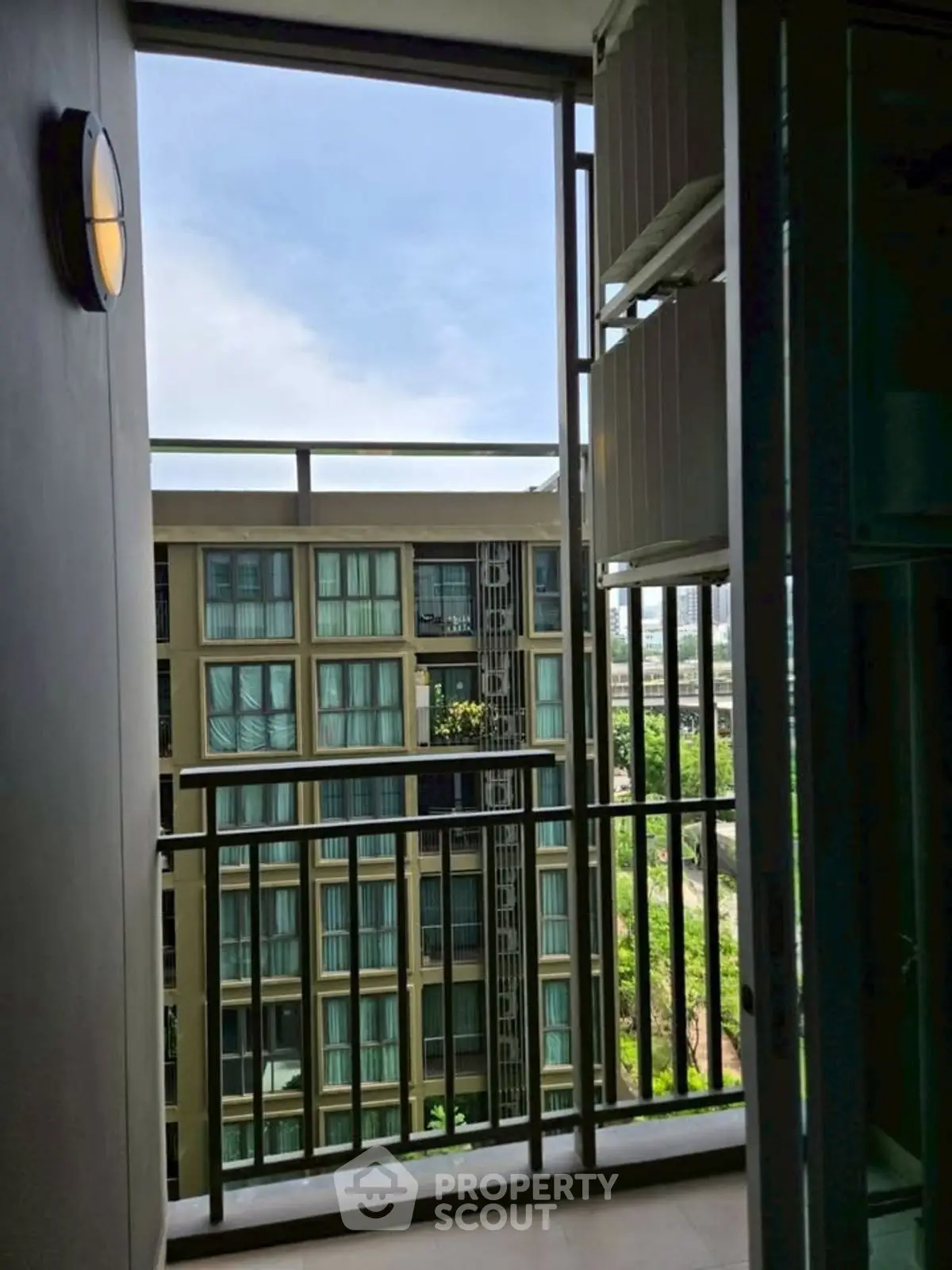 Modern apartment balcony with city view and sleek railing design.