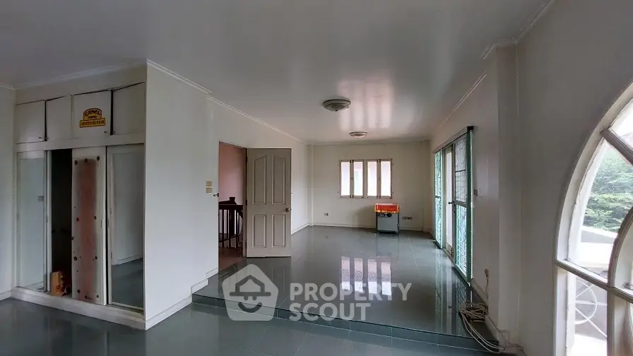 Spacious living room with large windows and glossy tile flooring