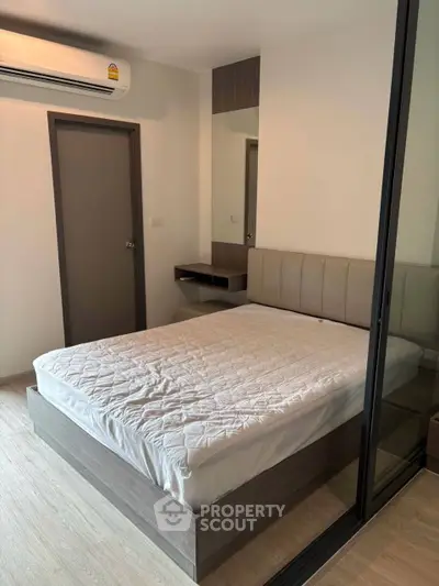 Modern bedroom with glass partition and sleek design in a contemporary apartment.