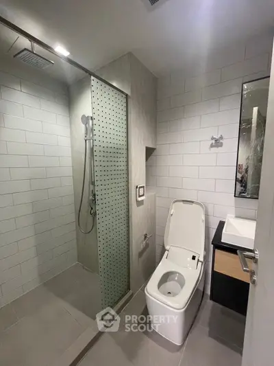 Modern bathroom with sleek shower and contemporary fixtures in a stylish apartment.