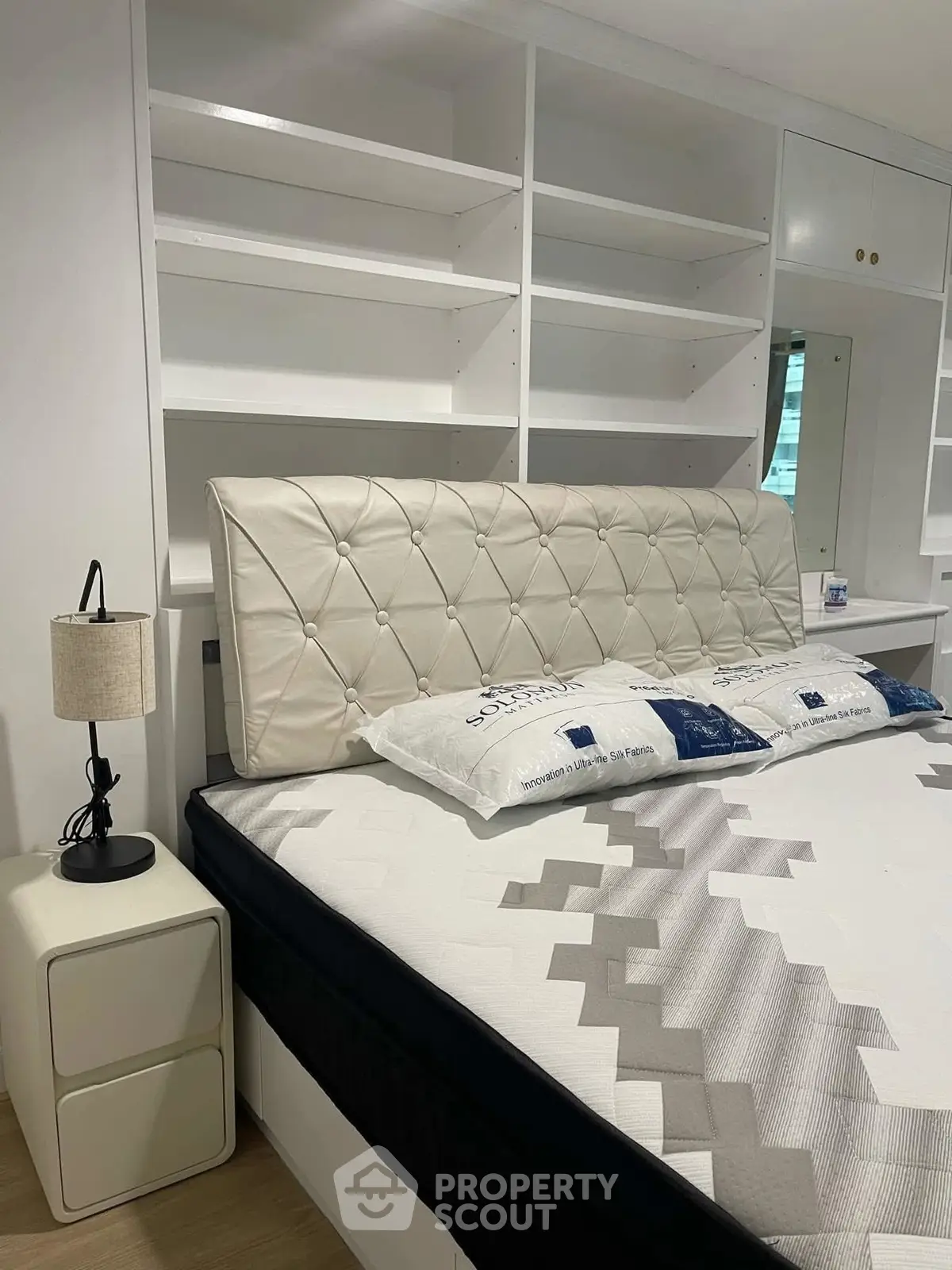 Modern bedroom with stylish headboard and built-in shelving