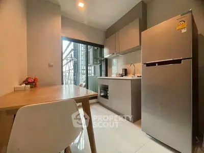 Modern kitchen with sleek appliances and dining area in a stylish apartment.
