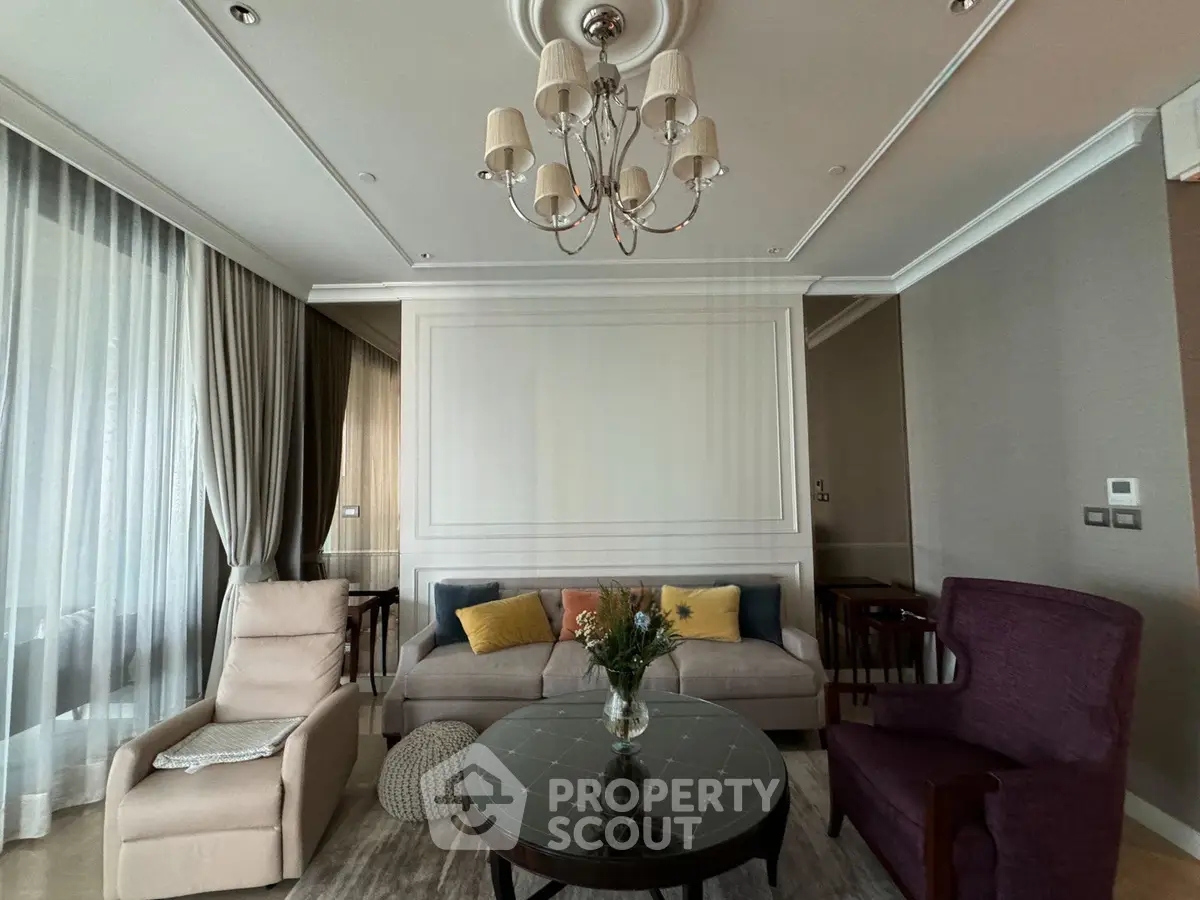 Elegant living room with plush seating and chandelier, perfect for relaxation and entertaining.