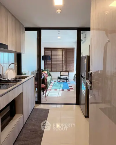 Modern kitchen with open layout leading to a stylish living room with chic decor.