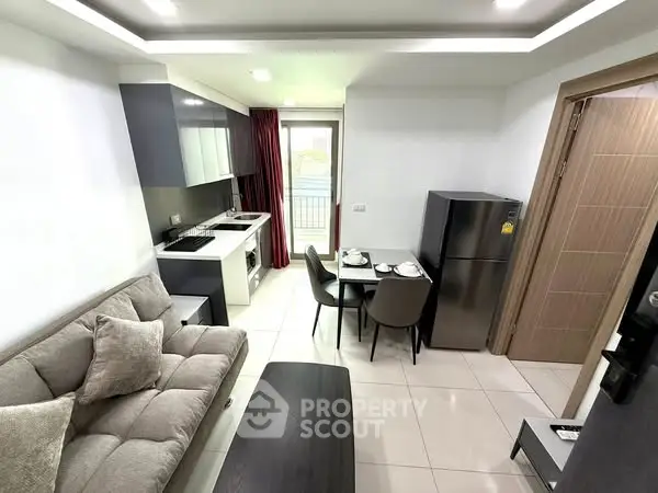 Modern open-layout living room and kitchen with sleek design and balcony access.