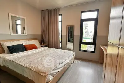 Modern bedroom with large windows and stylish decor in urban apartment