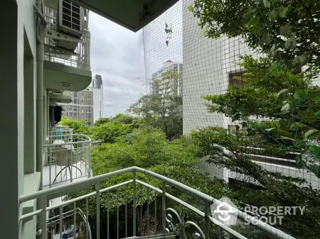 Charming balcony with lush greenery and city view, perfect for relaxation and enjoying nature.