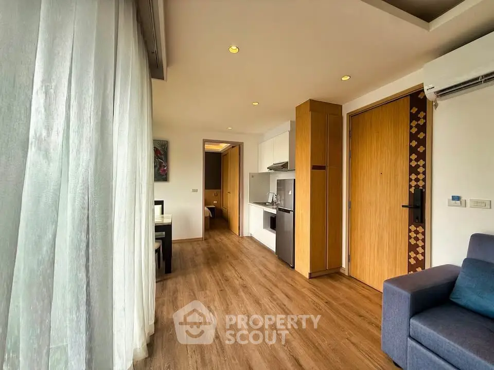 Modern apartment interior with open layout, featuring a cozy living area and sleek kitchen design.