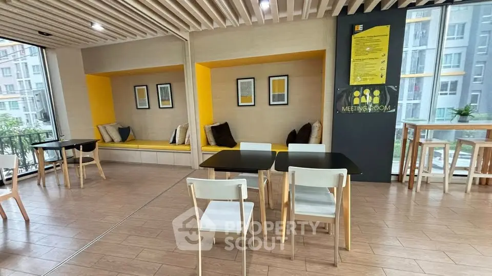 Modern meeting room with stylish seating and large windows in a contemporary building.