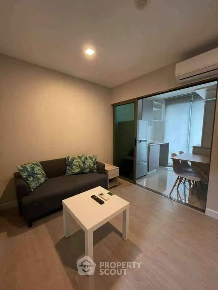 Cozy living room with modern furniture and open kitchen layout in a stylish apartment.