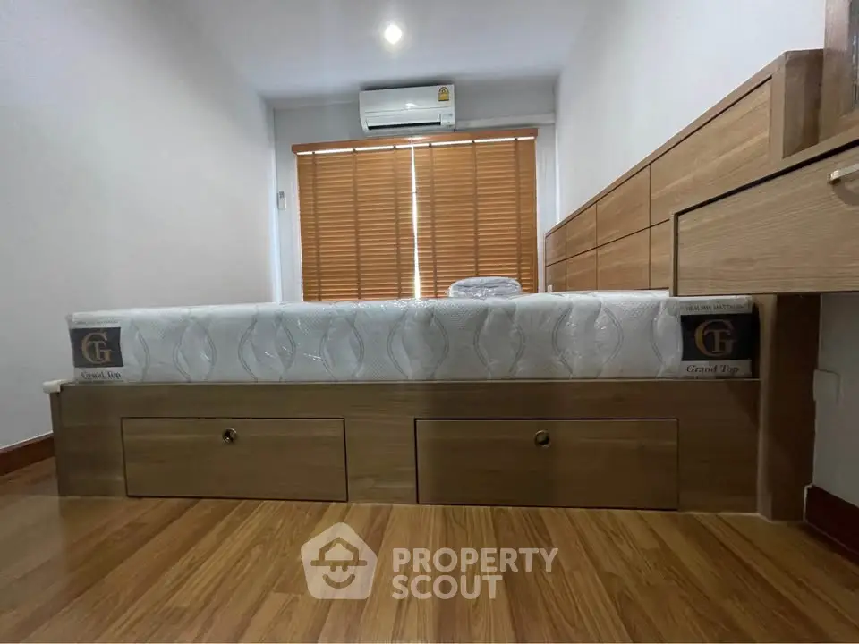 Modern bedroom with wooden flooring and built-in storage bed