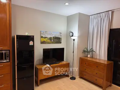 Charming living room with modern appliances and elegant wooden furniture, perfect for cozy living.