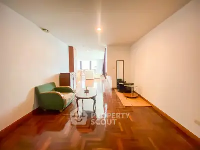 Spacious living room with elegant parquet flooring and cozy seating area.