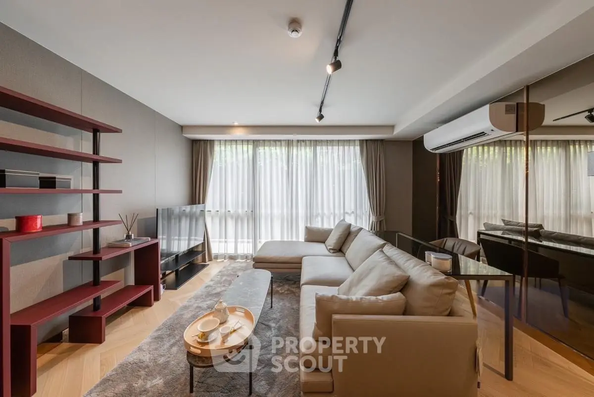 Modern living room with sleek design, large windows, and stylish furniture in a contemporary apartment.