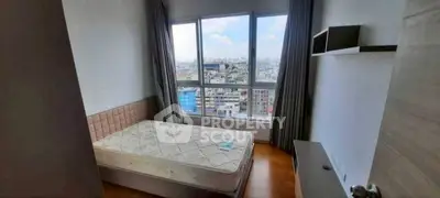 Cozy bedroom with city view, featuring a comfortable bed and large window for natural light.