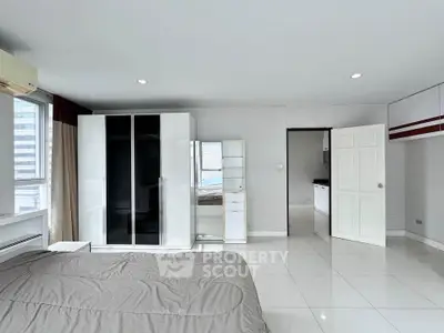 Spacious modern bedroom with sleek wardrobe and city view window