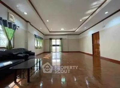 Spacious living room with wooden flooring and ample natural light