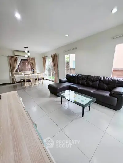 Spacious living room with modern furniture and natural light, perfect for family gatherings.