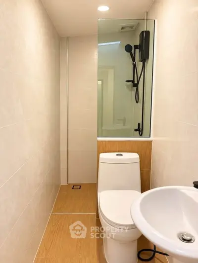 Modern bathroom with sleek fixtures and minimalist design, featuring a shower and toilet.