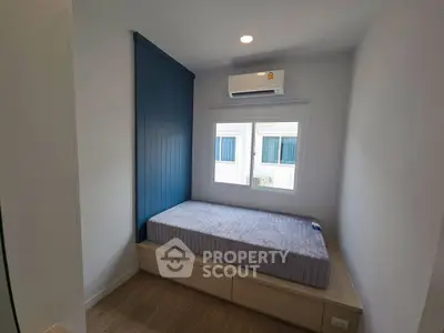 Cozy bedroom with modern design and natural light, featuring a built-in bed and air conditioning.