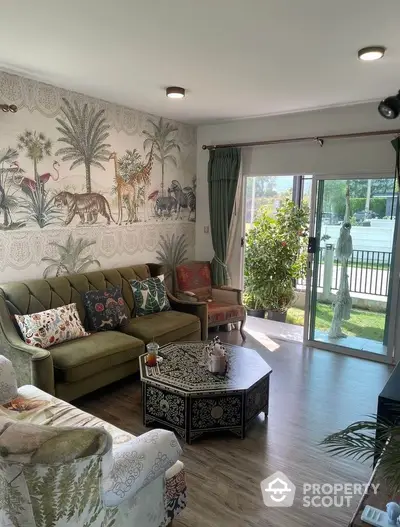 Charming living room with eclectic decor and garden view, featuring stylish furniture and vibrant wall art.