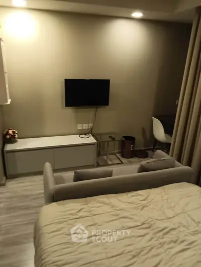 Cozy studio apartment with modern decor and wall-mounted TV, perfect for urban living.