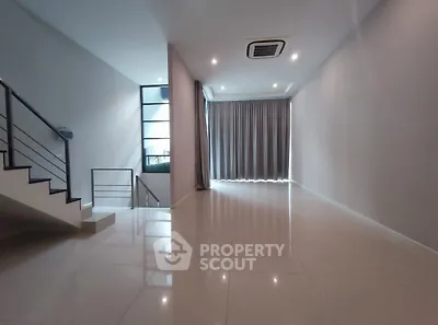 Spacious modern living room with sleek staircase and large windows