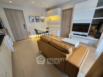 Modern living room with stylish furniture and open layout, featuring a cozy sofa and sleek dining area.