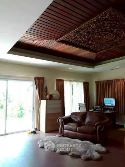 Spacious living room with elegant wooden ceiling and cozy leather sofa