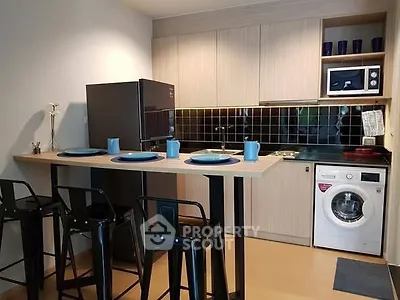 Modern kitchen with sleek appliances and stylish bar seating in a cozy apartment.