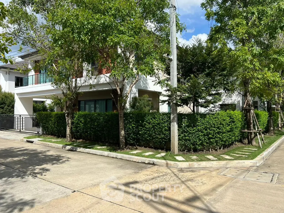 Modern corner unit house with lush garden and spacious driveway in a serene neighborhood.