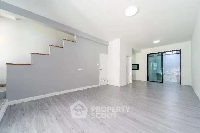 Spacious modern living room with sleek flooring and staircase