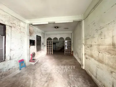 Spacious interior with potential for renovation, featuring high ceilings and natural light.