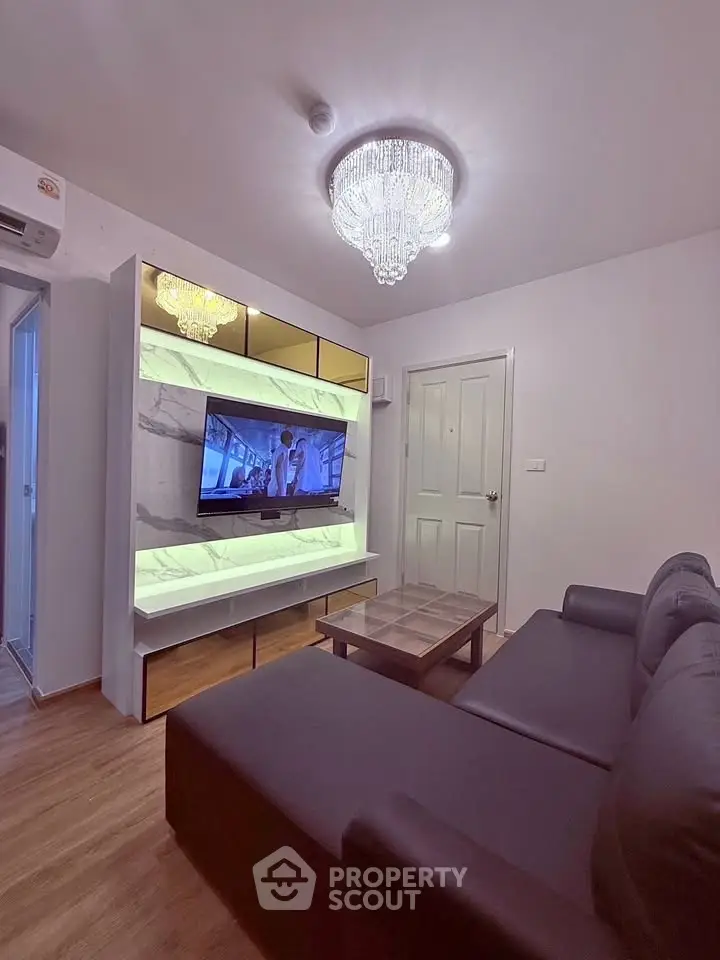 Modern living room with elegant chandelier and sleek entertainment center