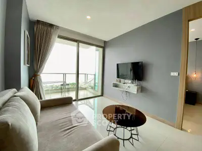 Modern living room with balcony view, featuring sleek furniture and a wall-mounted TV.