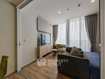 Modern living room with large windows and stylish furniture in a high-rise apartment.