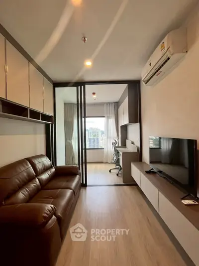 Modern living room with glass partition, leather sofa, and city view