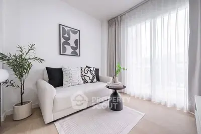 Modern living room with stylish decor and natural light, featuring a cozy white sofa and elegant curtains.