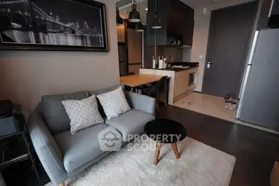 Modern living room with cozy sofa and stylish kitchen in open layout apartment.