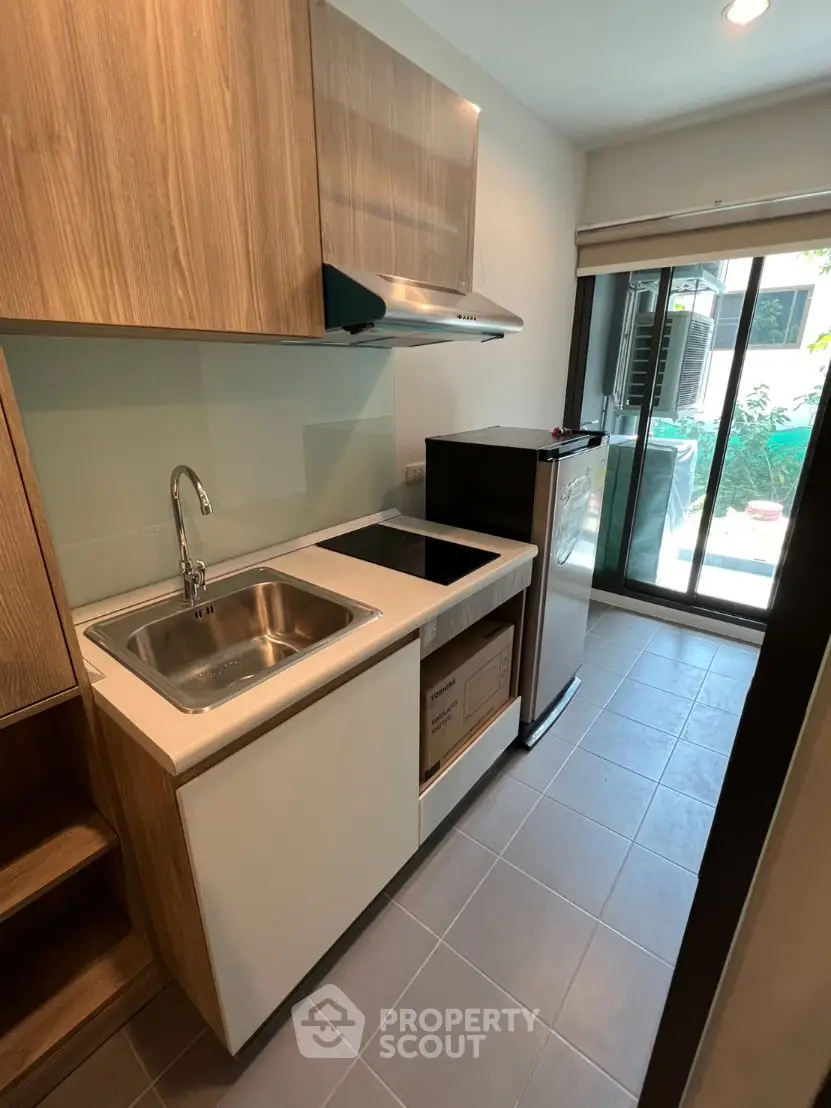 Modern compact kitchen with sleek cabinetry and large window view
