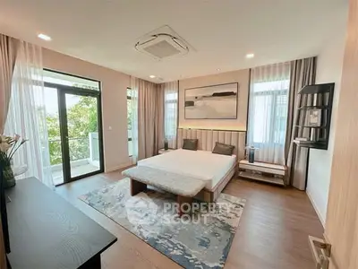 Luxurious bedroom with modern decor and balcony view, featuring elegant furnishings and natural light.