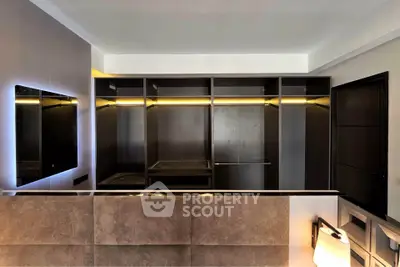 Luxurious walk-in closet with modern lighting and sleek design, perfect for organizing your wardrobe in style.