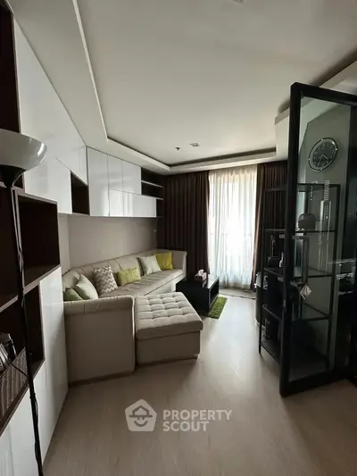 Modern living room with stylish sectional sofa and floor-to-ceiling windows for natural light.