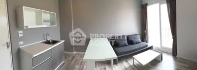 Modern living room with sleek furniture and natural light from large window.