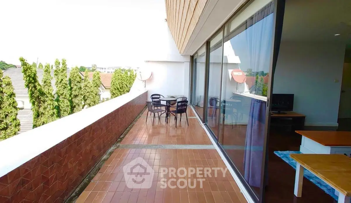 Spacious balcony with outdoor seating and scenic view, perfect for relaxation.