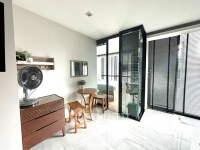Modern interior with glass-walled bedroom, stylish furniture, and natural light.